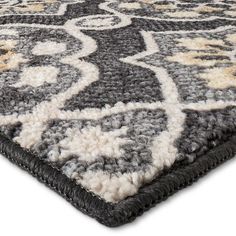 a gray and white rug with an intricate design on the bottom, in front of a white background