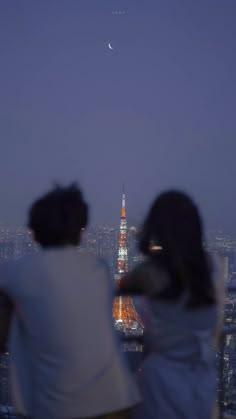 two people are looking at the city lights