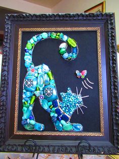 a cat made out of glass beads on a black frame