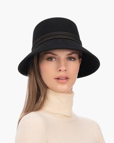 A fashionable women's cloche hat is hand-blocked of the finest superfelt, and then trimmed with a contrast stitch matching band of the same. The ultra sleek silhouette features a rakishly downturned brim, bringing focus to the eyes while framing the face beautifully. Brim span center front: 2.75"(7cm) side: 3"(7.5cm) Designed and finished in the USA Hand-blocked by skilled artisans Sustainable wool and cashmere blend superfelt Elasticized sweatband Adjustable head-size with hidden velcro® featur Fall Wide Brim Fur Felt Cloche Hat, Chic Wool Hat Bands, Chic Wool Cloche Hat, Elegant Wool Cloche Hat For Fall, Fitted Fur Felt Cloche Hat With Flat Brim, Fall Cloche Hat With Short Brim In Fur Felt, Fur Felt Cloche Hat With Short Brim For Fall, Fall Fur Felt Cloche Hat, Elegant Black Bucket Hat