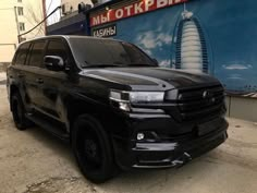 a black suv is parked in front of a building with a sign that says russian