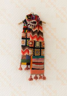 a multicolored scarf hanging on a wall