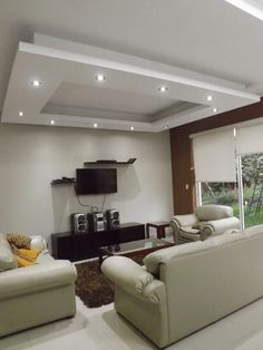 a living room filled with furniture and a flat screen tv on top of a wall