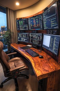 a desk with multiple computer monitors on it and a chair in front of the monitor