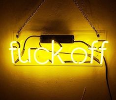 a neon sign that says fluckoff hanging from the side of a wall in a dark room