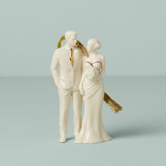 a wedding cake topper with a bride and groom figurine next to each other