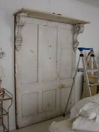 an old door is being painted white in a bedroom with a ladder leaning against it