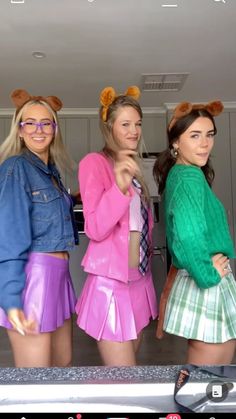 three young women dressed in costumes standing next to each other