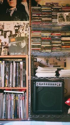 there is a wall full of records and cds in this room with an old stereo