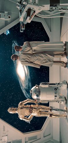 two men in space suits standing next to each other and looking up at the sky