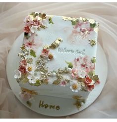 there is a cake with flowers on it and the words home written in white frosting