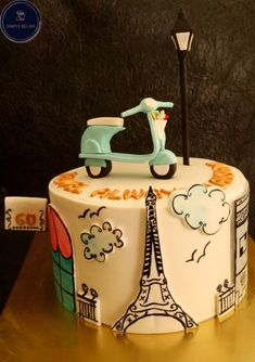 a cake decorated with the eiffel tower and a scooter