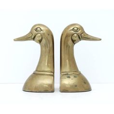 two brass ducks are standing next to each other