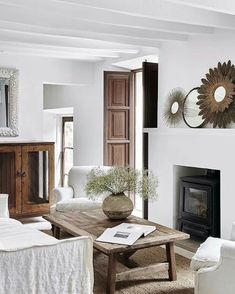 a living room filled with furniture and a fire place under a mirror on the wall