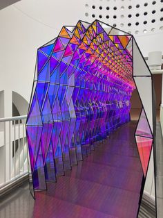 an art installation in the middle of a building with multiple colored structures on it's sides