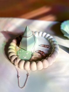 a white necklace and ring sitting on top of a table