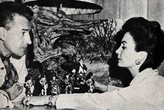 an old black and white photo of a man playing chess with a woman in front of him