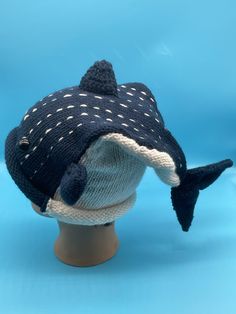 a knitted hat on top of a mannequin's head with a fish design