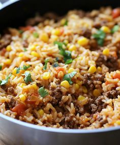 a pot filled with rice and vegetables on top of a wooden table