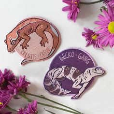 purple flowers and two patches with geckos on them sitting next to each other