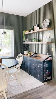 a dining room with green walls and white chairs