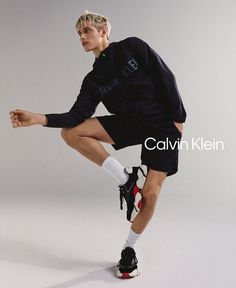 a man in black shirt and shorts holding a tennis racquet on white background