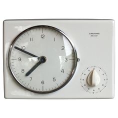 an analog clock with thermometer on it's side