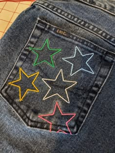 the back pocket of a pair of jeans with colored stars on it