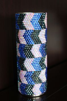 a blue and white vase sitting on top of a wooden table next to a wall