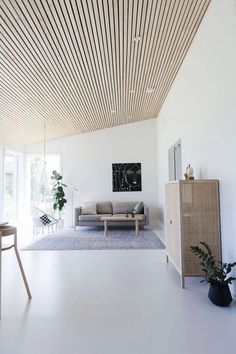 a living room filled with furniture and a wooden ceiling mounted to the side of a wall