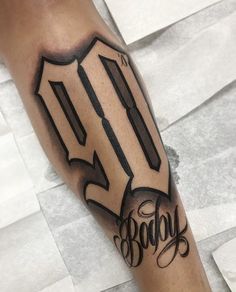 a man's arm with the number fifty and an arrow tattoo on his forearm