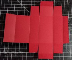 four pieces of red paper sitting on top of a cutting board next to each other