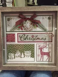 someone is holding up a framed christmas card