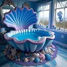 a large blue shell shaped bathtub sitting on top of a floor next to a window