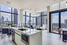 an open kitchen and living room area with large windows overlooking the cityscape in this modern apartment