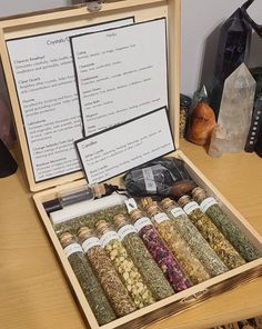 a wooden box filled with lots of different types of spices on top of a table