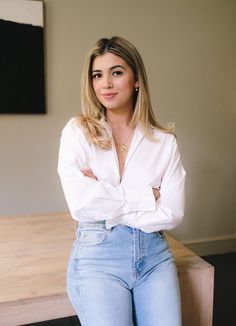 a woman with her arms crossed posing for the camera