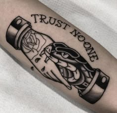 a black and white photo of a person's arm with a trust now tattoo on it