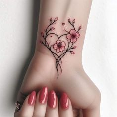 a heart shaped tattoo with flowers on the wrist