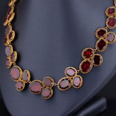 Experience the timeless elegance of this remarkable antique necklace dating back to the late Georgian era (circa 1820). Crafted with meticulous artistry, this exquisite piece showcases 54 oval flat-cut, foil backed garnets, set in 14k bloomed gold with closed backs, preserving their radiance for centuries. Measuring 16 inches in length, this antique necklace exudes a captivating charm and is in overall good condition. While there is one visible surface-reaching inclusion, it adds to the characte 1700s Jewelry, Georgian Necklace, Riviere Necklace, Georgian Era, Garnet Necklace, Antique Necklace, Stylish Jewelry, Gold Gold, Antique Jewelry