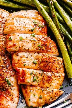 grilled chicken and asparagus on a plate with a fork next to it