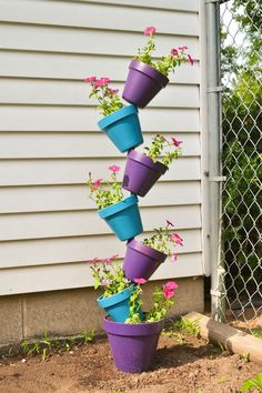 several purple and blue flower pots are stacked on top of each other