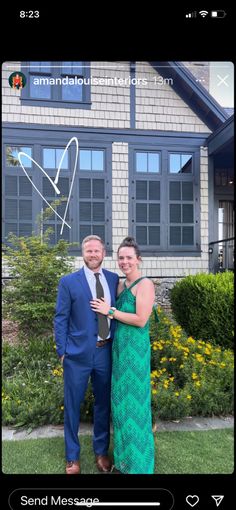 a man and woman standing in front of a house