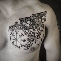 a man with a tattoo on his chest has a wolf in the middle of it