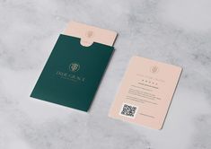 a green and pink business card sitting on top of a marble table next to a qr code