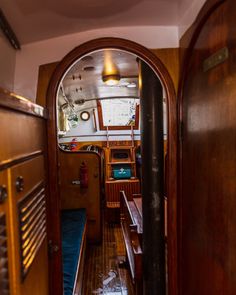 the inside of a boat looking through an open door to another room with wood floors