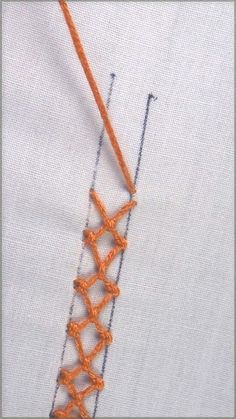 an orange crochet stitch on top of a white shirt