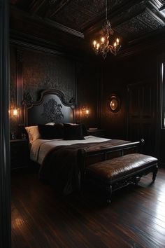 a large bed in a dark room with chandelier hanging from it's ceiling