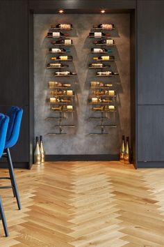 two blue chairs sitting in front of a wine rack