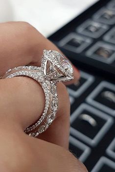 a person holding a diamond ring in their hand